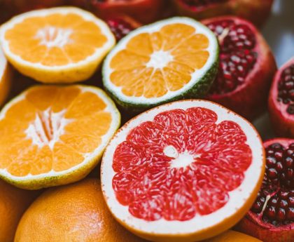 Vibrant close-up of sliced citrus fruits and pomegranates showcasing freshness and variety.